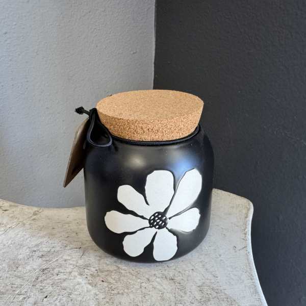 Black jar with a cork lid and white flower design