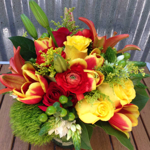 Bright bouquet of red and yellow flowers in a glass vase