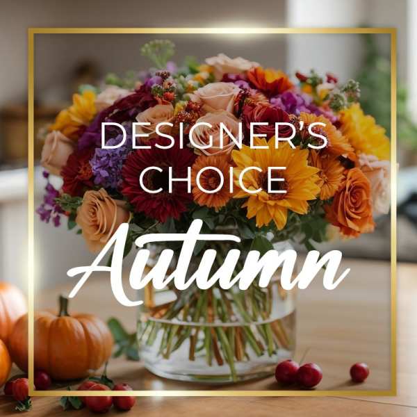 Mixed autumn bouquet in a glass vase with pumpkins and berries
