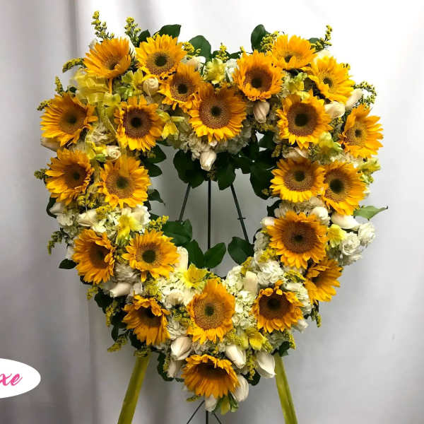 Heart-shaped sunflower wreath on a stand with white flowers