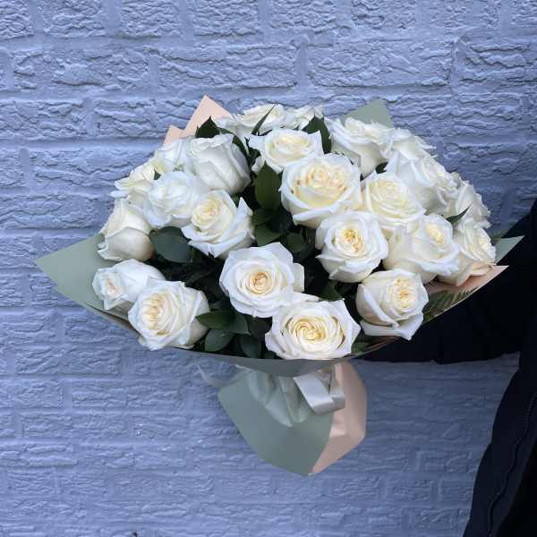 Bouquet of white roses wrapped in pastel paper