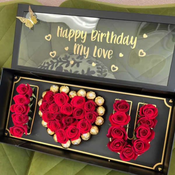 Boxed red roses arranged with chocolates and a birthday message
