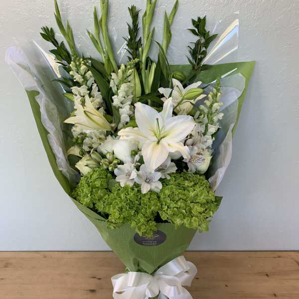 White lily bouquet with green hydrangea and a white ribbon