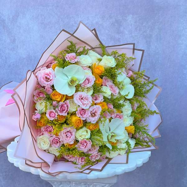 Large bouquet of pink and white roses with pale orchids and yellow accents