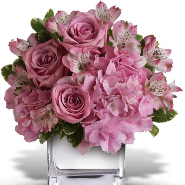 Pink roses and hydrangeas in a clear square vase