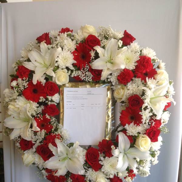 Heart-shaped wreath of red and white flowers on an easel
