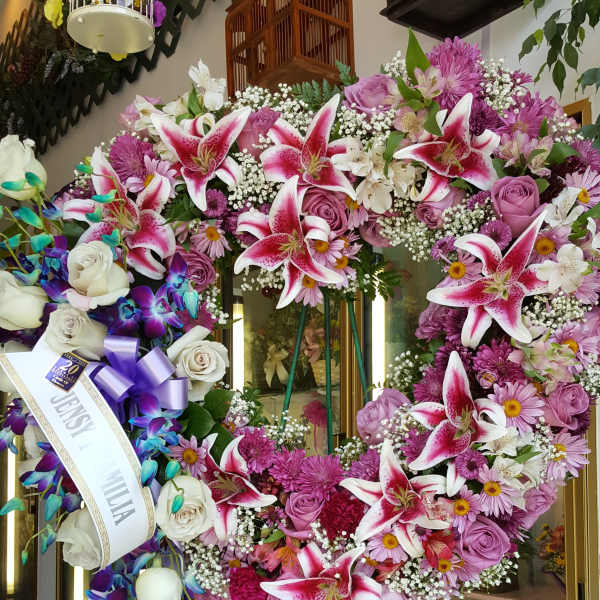 Large heart-shaped floral standing wreath with pink lilies and roses