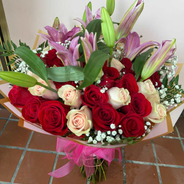 Bouquet of red and blush roses with pink lilies and baby's breath