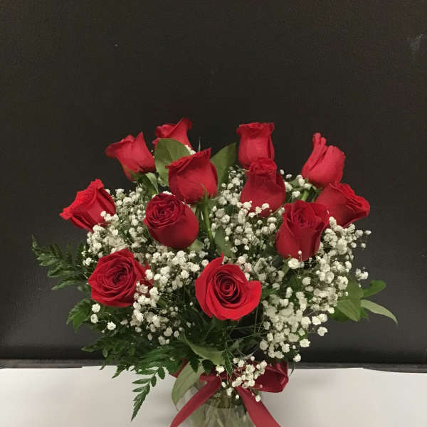 Bouquet of red roses and baby's breath in a glass vase