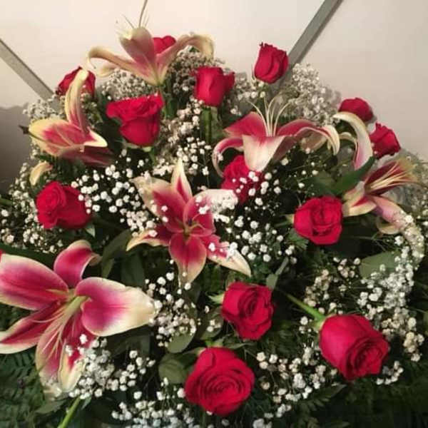 Arrangement of red roses and pink lilies with baby's breath
