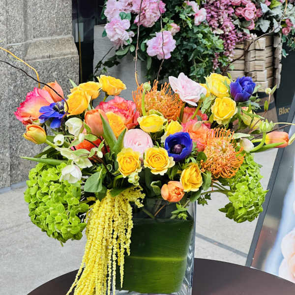 Colorful mixed flower arrangement in a square glass vase