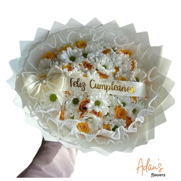 White and yellow flower bouquet with a "Feliz Cumpleaños" ribbon
