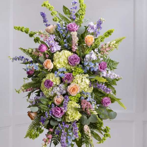 Tall standing floral spray with roses, hydrangeas, and purple blooms