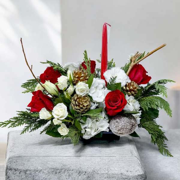 Red and white floral centerpiece with candles and pinecones