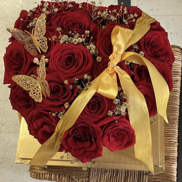 Heart-shaped bouquet of red roses with gold ribbon and butterfly accents