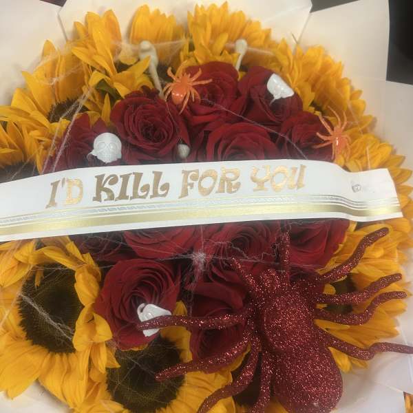 Bouquet of red roses and yellow sunflowers with Halloween decorations