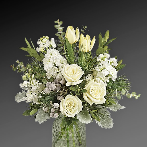 White roses and tulips arranged in a glass vase