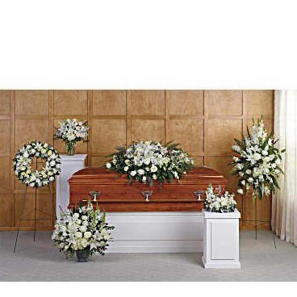 White funeral flowers arranged around a casket