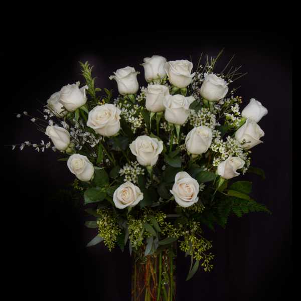 White roses arranged in a clear glass vase
