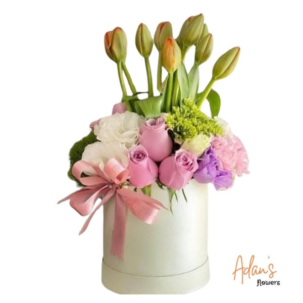 Pink and white floral arrangement in a white hatbox with a ribbon bow