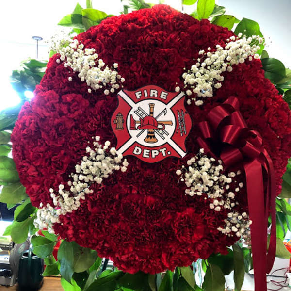Red floral fire department wreath with white baby's breath and a ribbon