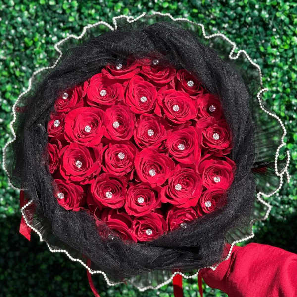 Bouquet of red roses wrapped in black fabric with rhinestone accents
