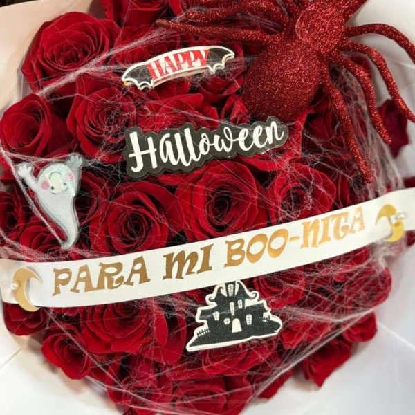 Red rose bouquet with Halloween decorations and a glittery spider