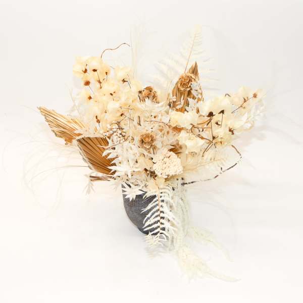 Cream dried floral arrangement in a dark vase