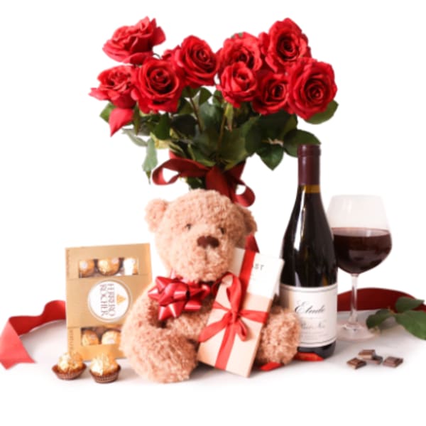 Red rose bouquet with a teddy bear, wine, chocolates, and a gift box