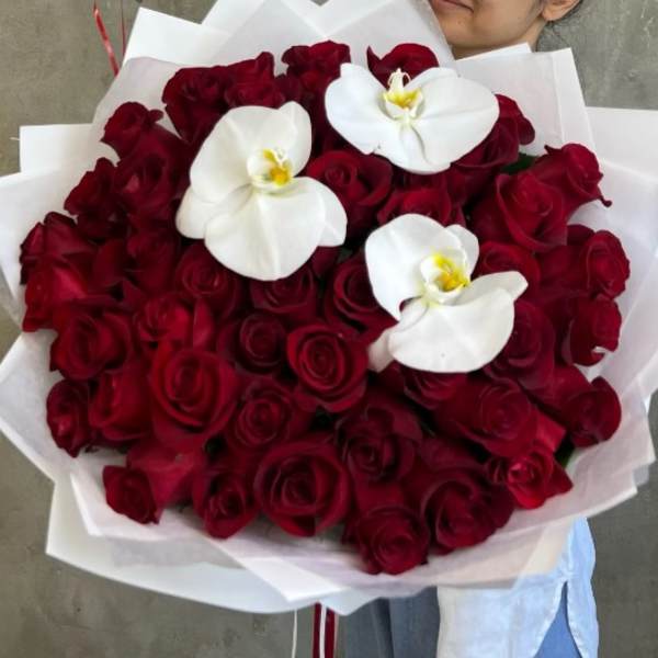 Bouquet of red roses with three white orchids wrapped in white paper