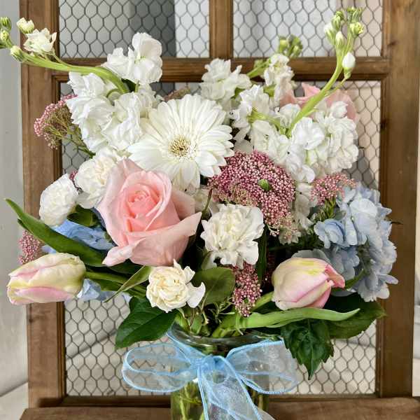 Pastel bouquet in a glass vase with a blue ribbon