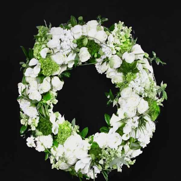 White floral wreath with roses and orchids on a black background
