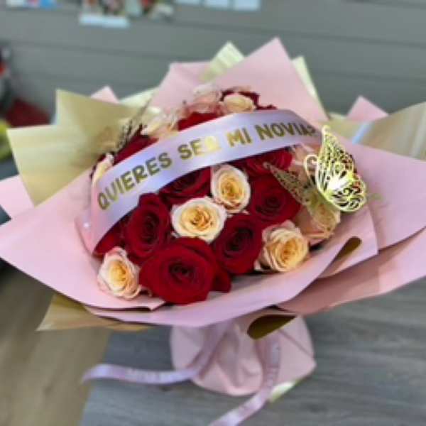 Bouquet of red and cream roses wrapped in pink paper