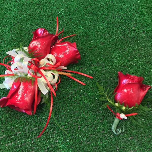 Red rose bouquet and matching boutonniere on green turf