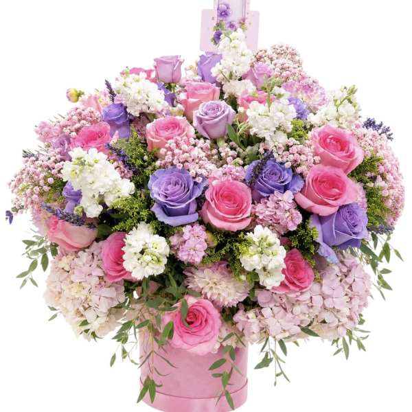 Large bouquet of pink and purple roses in a pink hatbox