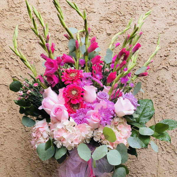 Pink and lavender bouquet in a glass vase with tulle ribbon
