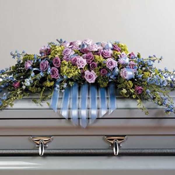 Lavender and blue floral spray on a casket