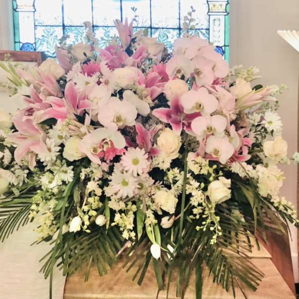 Large pink and white floral arrangement with orchids and lilies