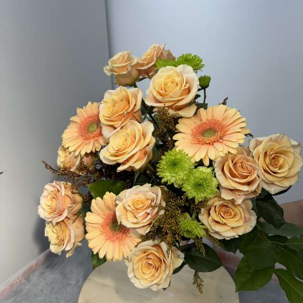 Bouquet of peach roses and peach gerbera daisies