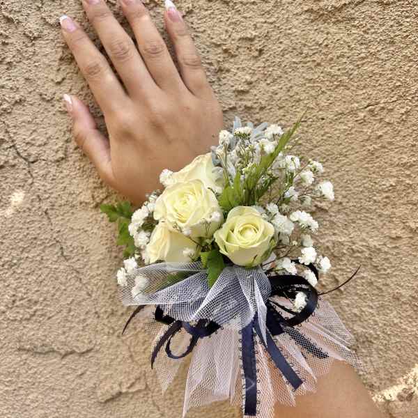 Small wrist corsage with cream roses and white baby's breath