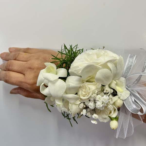 White floral wrist corsage with ribbon and tulle