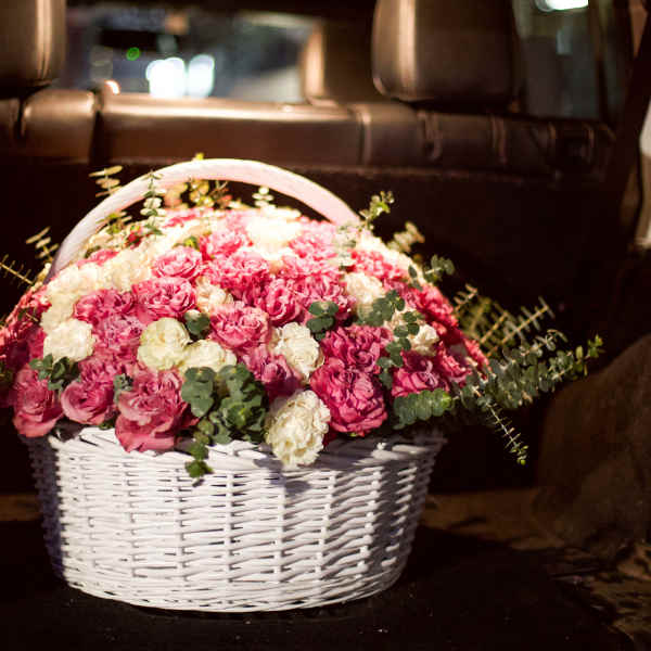 Basket of pink and white roses in a car interior