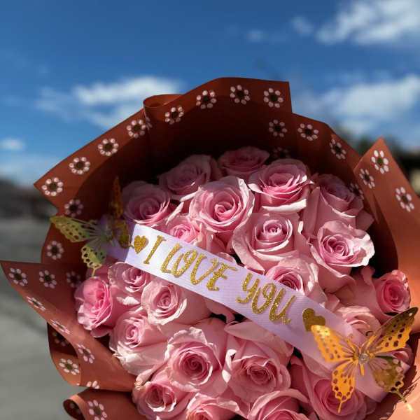 Pink roses in decorative wrap with a "I LOVE YOU" ribbon