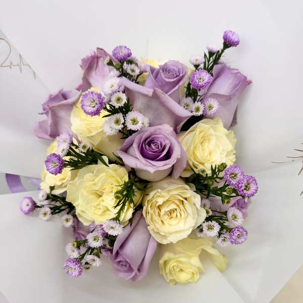 Bouquet of lavender and cream roses with small purple filler flowers