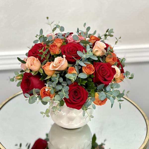 Bouquet of red and peach roses in a white vase