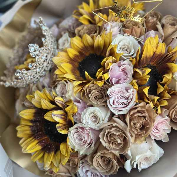 Bouquet of sunflowers and pastel roses with a birthday topper