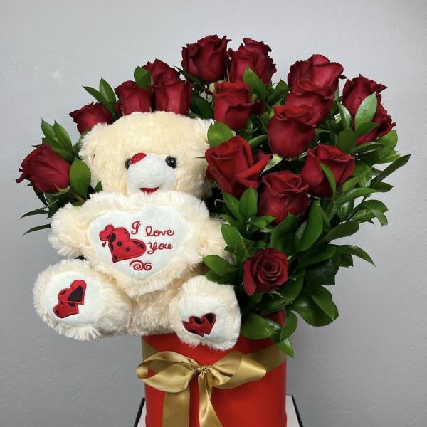 Red roses arranged with a teddy bear in a red gift box