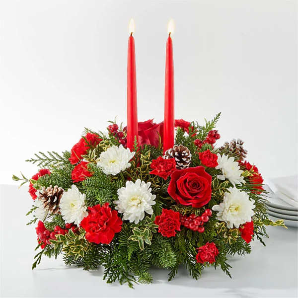 Holiday centerpiece with red candles, roses, carnations, and white daisies