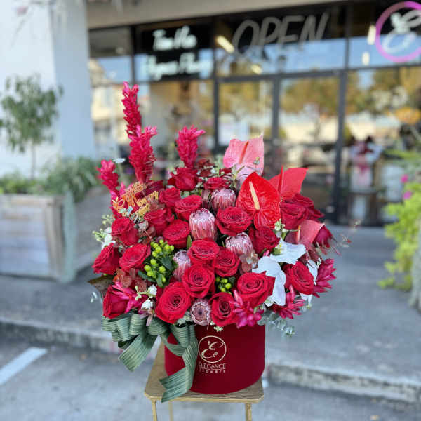 Red rose arrangement in a velvet box with a ribbon bow