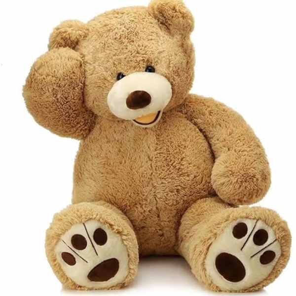 Plush teddy bear sitting with one paw raised to its head